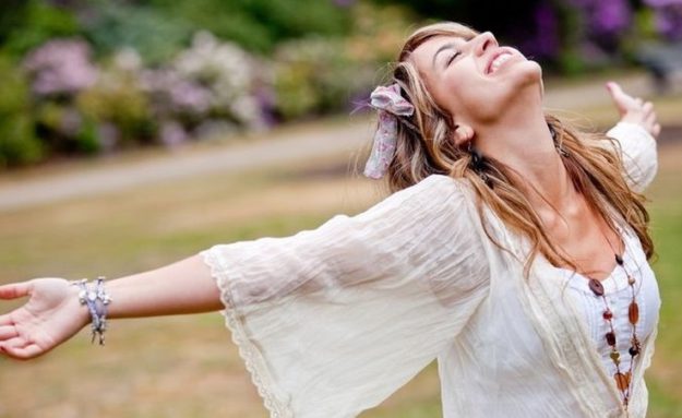 Happy woman with opened arms outdoors enjoy her freedom